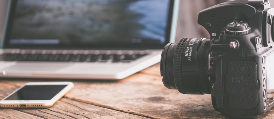 black dslr camera on beige wooden surface